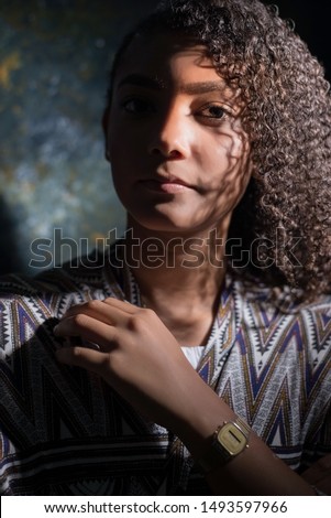 art portrait of a latin american girl. Beautiful mexican woman, on abstract dark background. Artistic dramatic light.