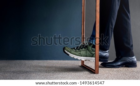Work Life Balance Concept. Challenging to Change. Low Section of Businessman Steps passing a wooden frame. Half is a Formal Dress and other side is a Casual Traveling Shoes  Royalty-Free Stock Photo #1493614547
