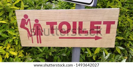 Funny sign showing a man spying a woman in the toilet