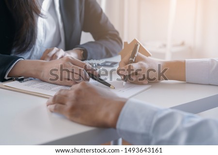 Salesmen are letting the male customers sign the sales contract, Asian women and men are doing business in the office, Business concept and contract signing Royalty-Free Stock Photo #1493643161