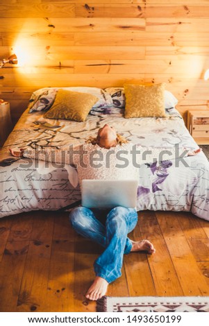 Relaxed or stressed people caucasian woman at home or hotel room with computer laptop - concept of stress and tired lady with technology - beautiful interior in wood