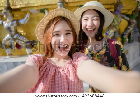 young tourist women in taking selfie picture, enjoy travel in the palace temple in Bangkok of Thailand, Emerald Buddha Temple, Wat Phra Kaew, Bangkok Royal Palace popular tourist place
