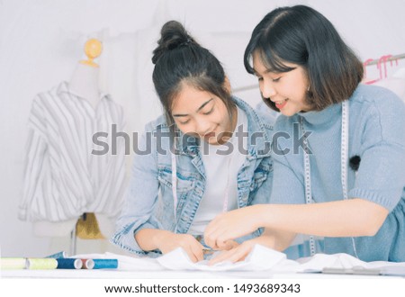 Asian family of fashion designers are working at home.Attractive young girl and stylish beauty women in process of creating new clothes collection.Designers and editors are designing clothes at room