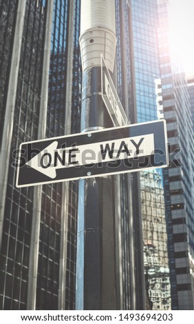 One way street sign against the sun in New York City, color toning applied, USA.