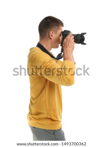 Young professional photographer taking picture on white background
