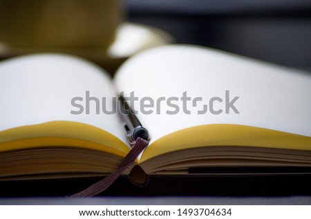Open book with a black pen on the middle