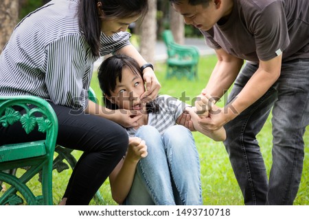 Sick child girl with epileptic seizures in outdoor park,daughter suffer from seizures,illness with epilepsy during seizure attack,asian mother,father care of girl patient,brain,nervous system concept Royalty-Free Stock Photo #1493710718