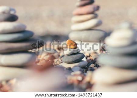 Zen pyramid of spa stones on the blurred sea background. Sand on a beach. Sea shores. Place for text.	