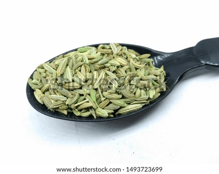 A picture of fennel seed's on black spoon