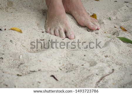 Closeup barefoot in sand beach background.