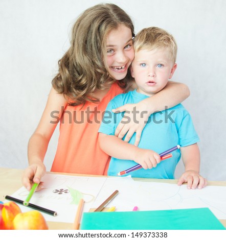 Boy and girl drawing with colourful pencils.