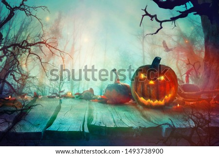 Halloween with Pumpkins and Dark Forest. Scary Jack O' Lantern Halloween Design on Table