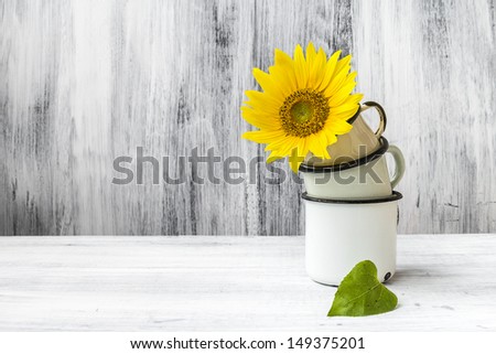 Still life with flower on pyramid of tin cups