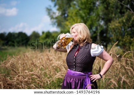 
attractive Bavarian woman in nature with beer glass, picture with copy space