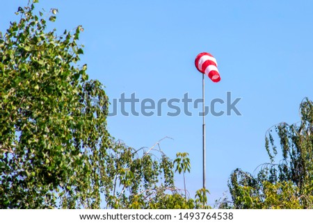 Windsock indicating wind on blue sky background.