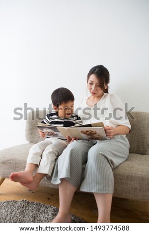 Pregnant woman reading a picture book for a boy