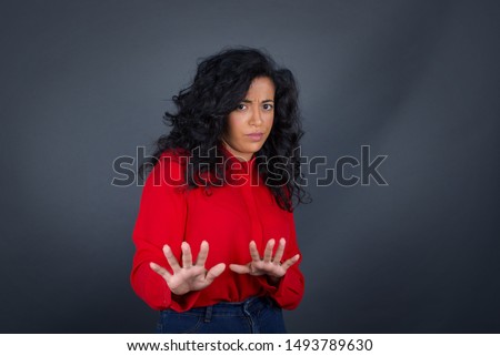 Beautiful brunette girl over isolated background afraid and terrified with fear, and disgusted expression stop gesture with both hands saying: Stay there. Panic concept