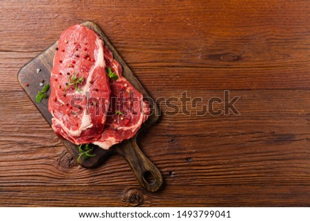 Raw beef steak, ready for grilling. Grill accessories. Concept. Free space for description. Top view. Royalty-Free Stock Photo #1493799041