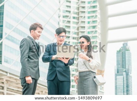 Businessmen and businesswomen stand to discuss and contact outdoor work about company projects,with city background,concept of work agility and meetings to discuss offsite jobs unofficial