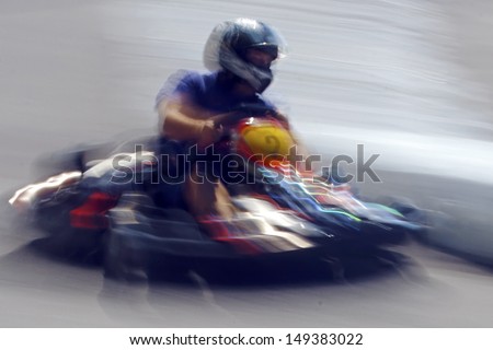 Abstract image with a moving kart man on blurred background.