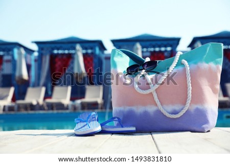 Beach accessories near swimming pool on sunny day. Space for text