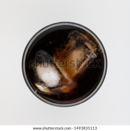 Top - down photo of a glass of cola covered with bubbles. Flat lay soda glass. Royalty-Free Stock Photo #1493835113