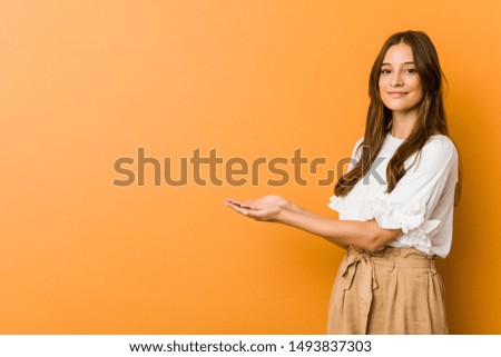 Young caucasian woman holding a copy space on a palm.