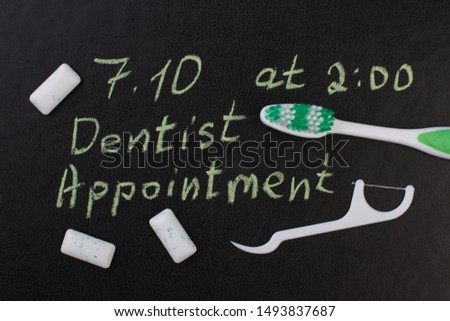Toothbrush, dental floss and inscription dental appointment. Marked date and toothbrush to remind dentist appointment day in october.