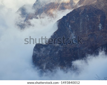 Clouds and rocky peaks at dawn in front of the Tholobugin Pass, on the way to the Annapurna North Base Camp.