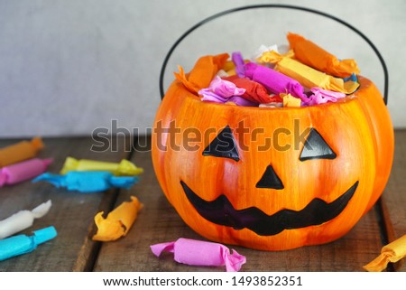Pumpkin with candy on gray background for halloween party night.