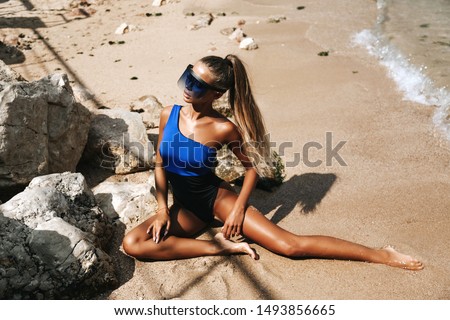 fashion outdoor photo of beautiful girl with dark hair in luxurious swimming suit relaxing at the beach