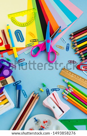 Colorful school supplies on the pastel blue color surface,made a frame with blank copy space