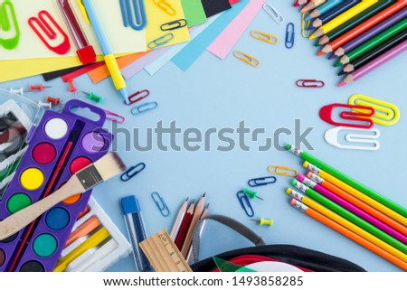 Colorful school supplies on the pastel blue color surface with blank copy space