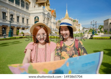 tourist women in exciting discuss find location in map guide information to visit the palace temple in Bangkok of Thailand, Emerald Buddha Temple, Wat Phra Kaew, the Royal Palace popular tourist place