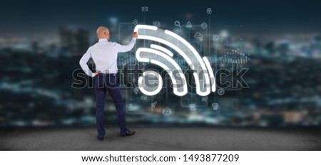 View of a Businessman holding a wifi icon with data all around