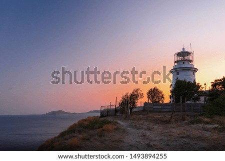 White sea lighthouse in Feodosia, Crimea on the Black Sea at sunset