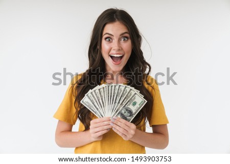 Image of a happy excited young girl isolated over white wall background holding money.