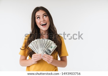 Photo of a happy dreaming young girl isolated over white wall background holding money.