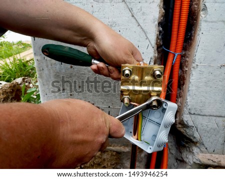 The master performs welding of a copper tube near a dwelling house.