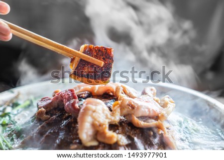  Close-up of Hand Holding Chopsticks Eating Unhealthy Thai Barbecue, Oily Grilled Pork