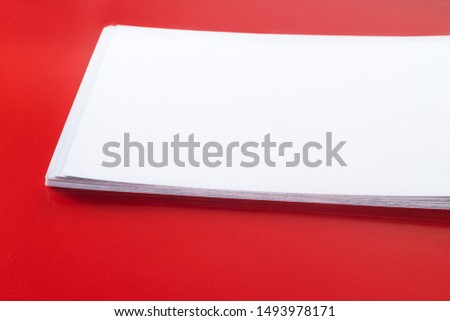 Close up stack of blank name cards, white empty business card, poster or flyer on red texture. Blank signboard with copy space area for text or slogan