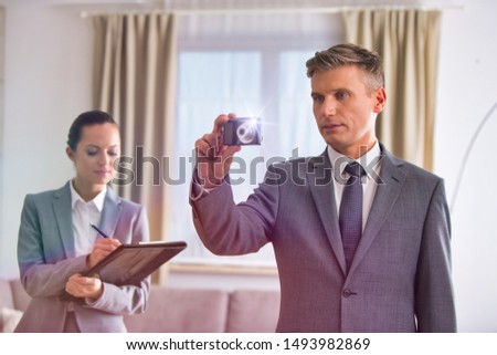 Salesman taking pictures of apartment interior for sale