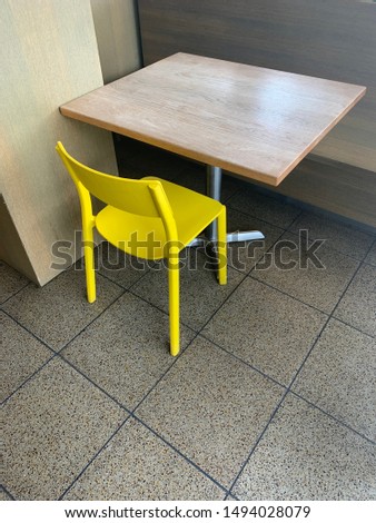 A pop of color with a yellow chair at a wood table