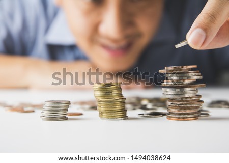 Male hand putting money coin stack growing, Saving money concept Royalty-Free Stock Photo #1494038624