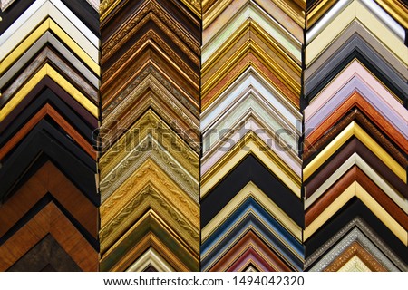 interior.  picture frame.  many different wooden corners - examples of framing paintings.  Brown color wall . Arrow , geometry. Background . acceleration symbol