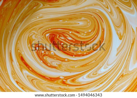stains of orange water-based paint, background. paint mixing process. The process of mixing orange and white emulsion paint