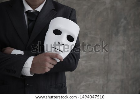 Businessman holding white mask in his hand dishonest cheating agreement.Faking and betray business partnership concept Royalty-Free Stock Photo #1494047510