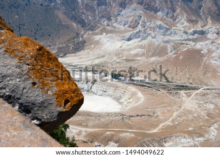 Greece, Nisyros island. Yellow stone and crater of volcano on the background