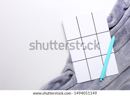 Composition of grey plaid, notebook and pen on white background with copy space. Autumn and winter, creativity concept. Flat lay. Top view.