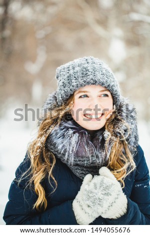 A girl in winter, a walk in the Park or forest. Girl student or Manager in winter down jacket, hat in winter.